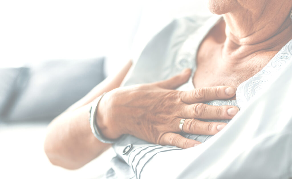 Woman holds hand to breastbone because of heartburn