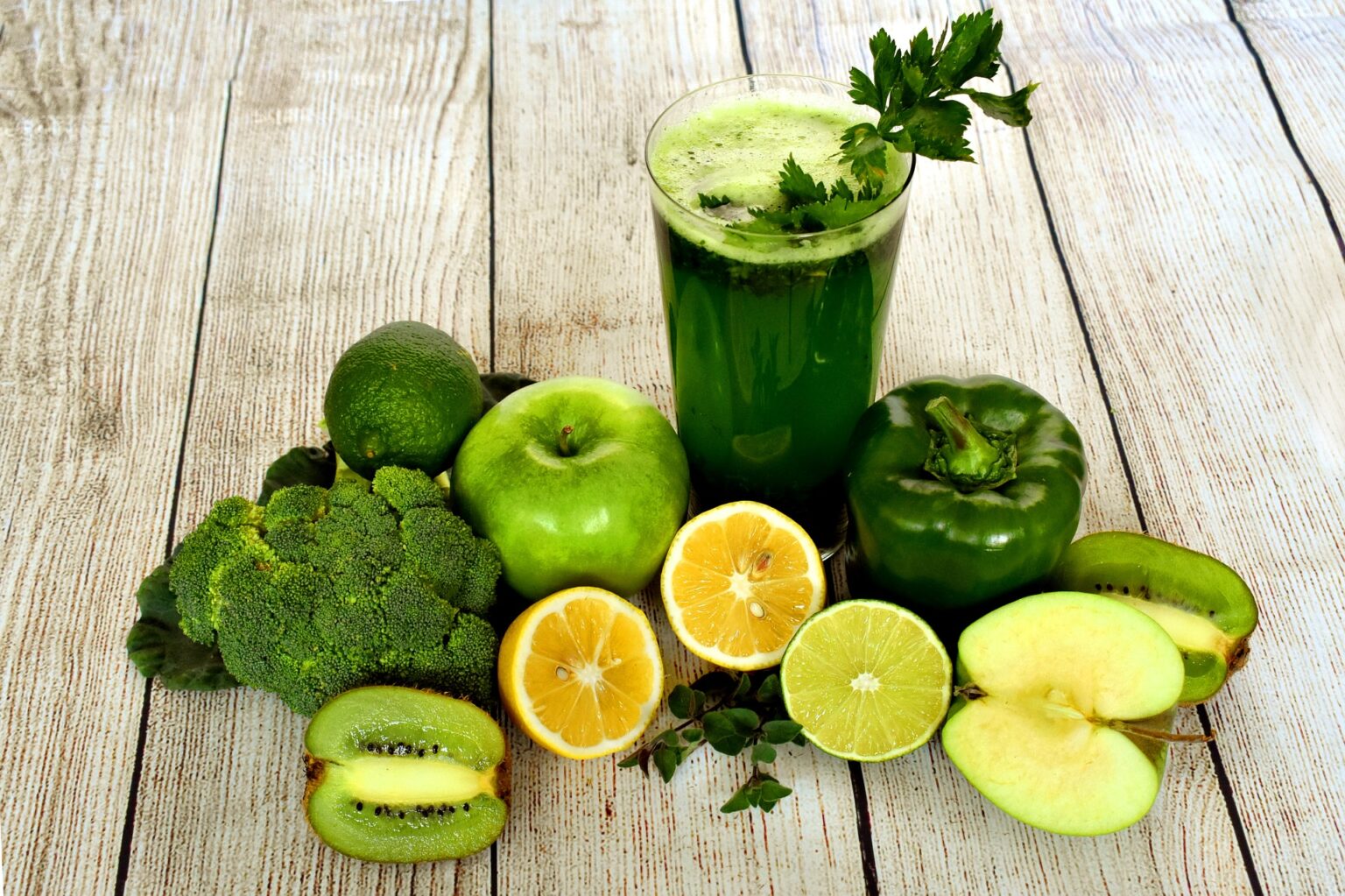 glass with green juice and fruit and vegetables