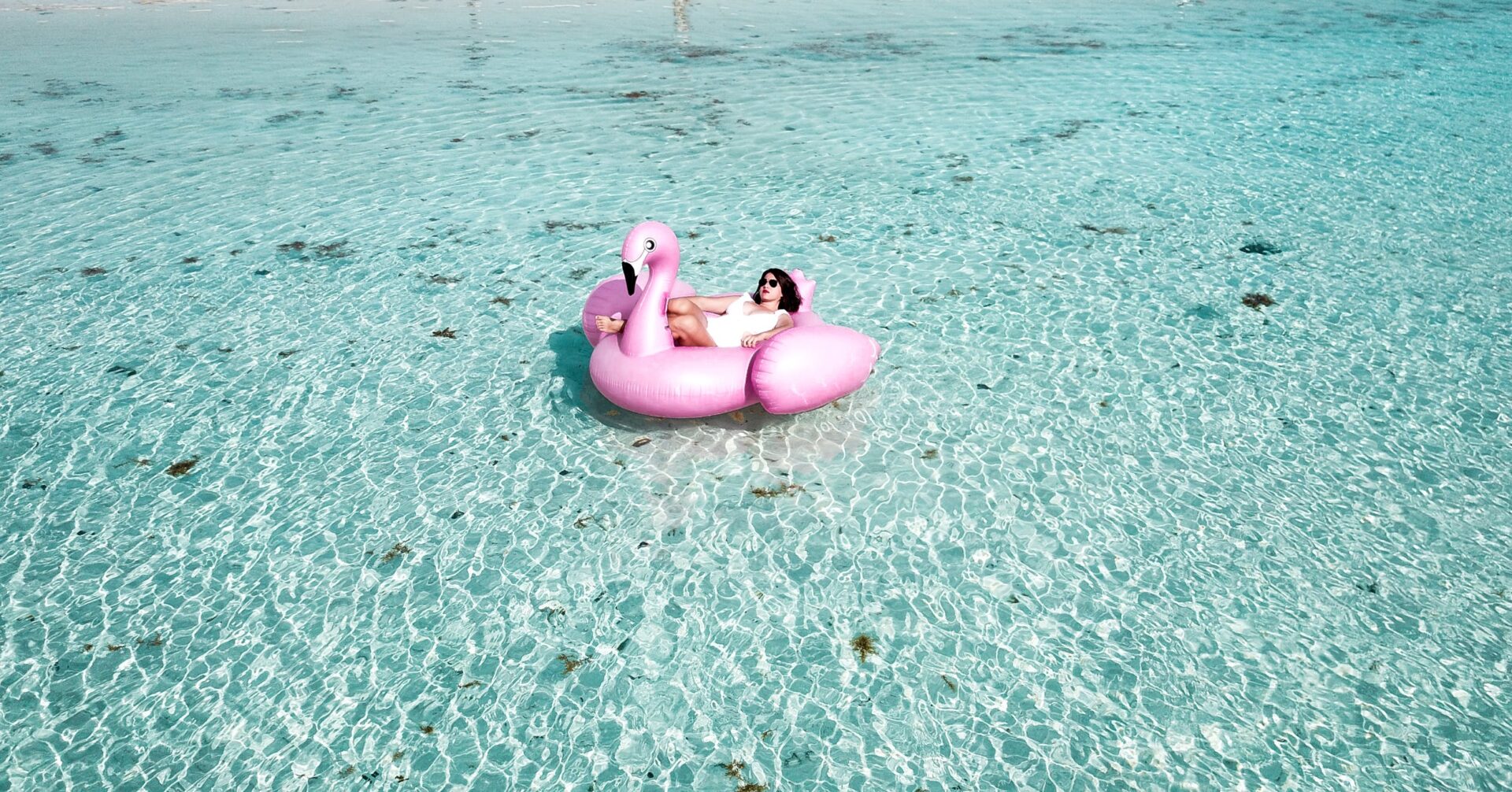 Frau liegt auf Flamingo im Meer