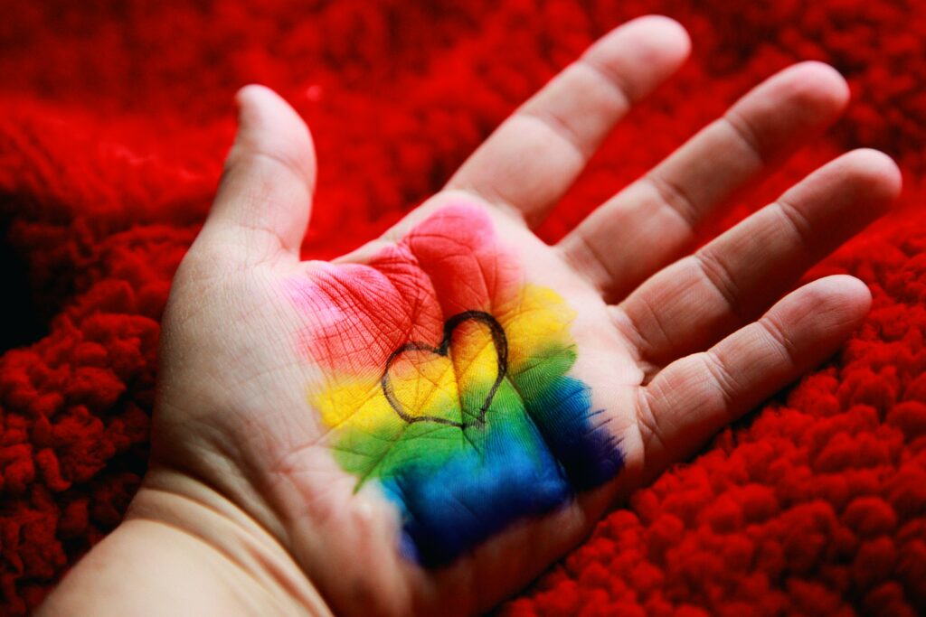 Regenbogen und Herz in Handfläche