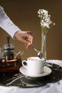 a woman stirs her chamomile tea with her spoon