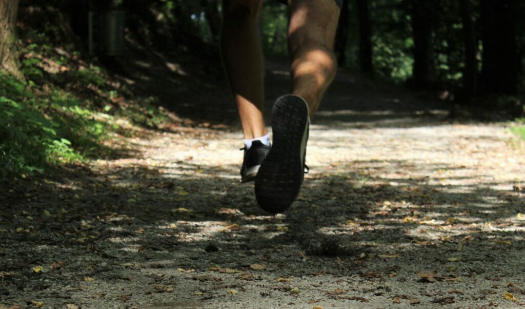 Legs and feet jogging in the shady forest