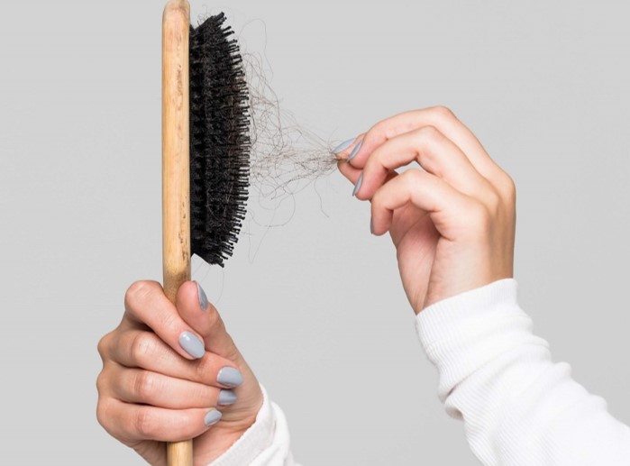 woman hand plucks hairbrush and pulls out hair
