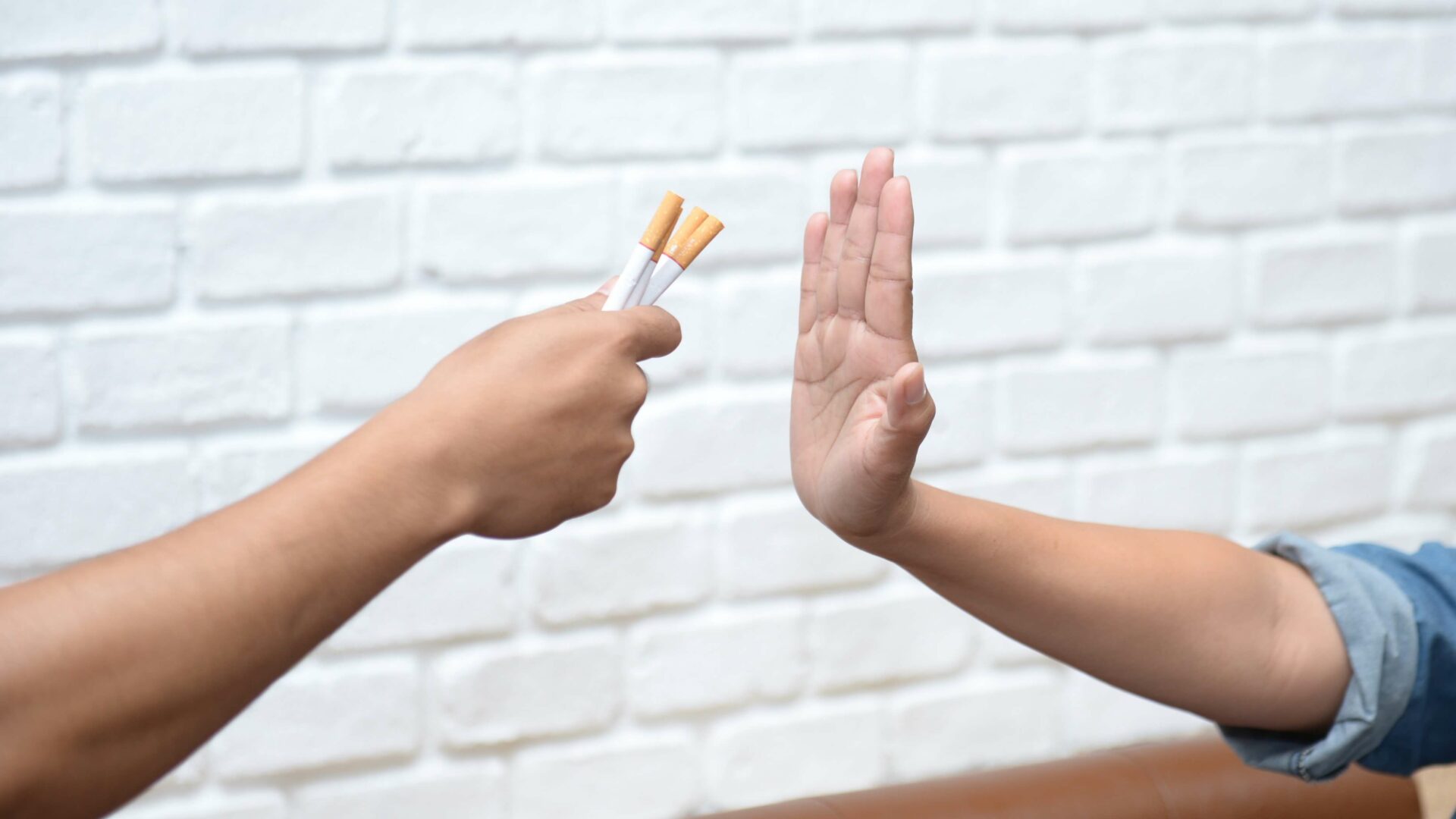 zwei hände, die eine will zigaretten anbieten die andere sagt nein