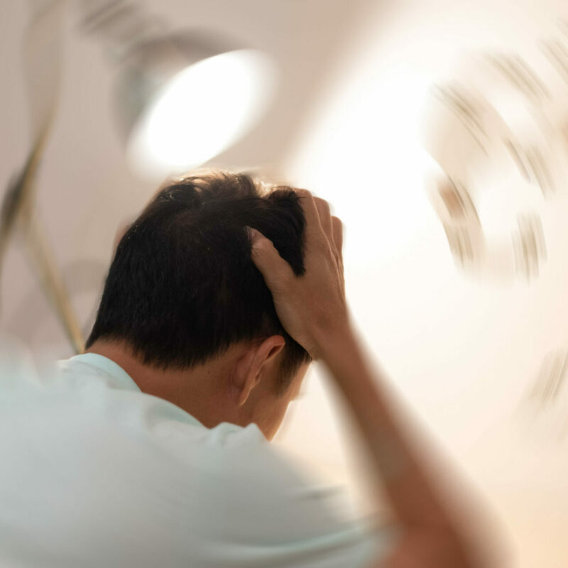 Man holding his head with blurred background
